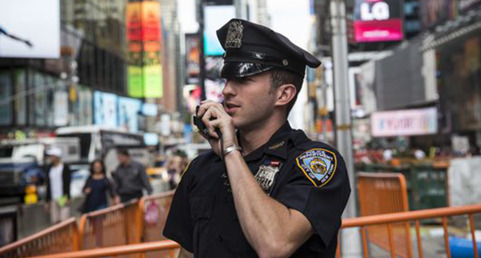 A New York Police Department (NYPD) officer speaks on his radio in Times Square in 2013. New York's fiscal 2015 budget includes money for the NYPD to hire 200 administrative aides to free officers from desk work. (Photo: Andrew Burton Getty Images)