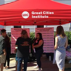 GCI staff connecting with community members under a tent, sharing work and building solutions together, reflecting the vision to address cities’ complex challenges.