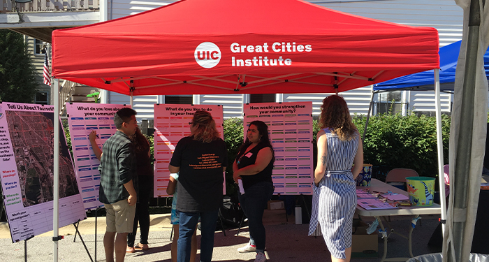 Group of people looking at posters under a GCI tent