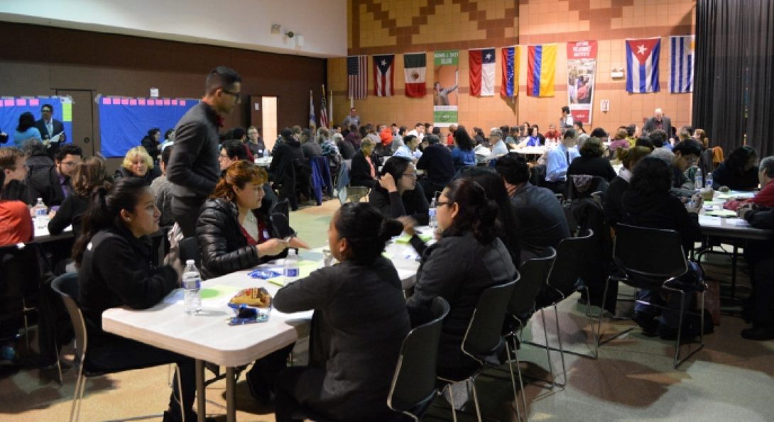 Many people sitting at tables in an auditorium