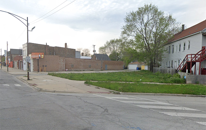 Empty lot on a street corner with one tree