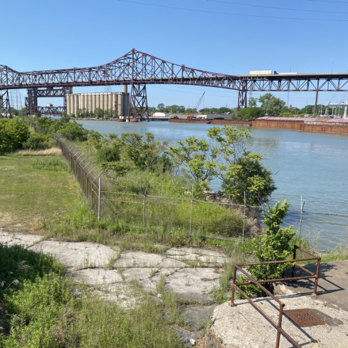 Empty green space along the Calumet river with a bridge in the background