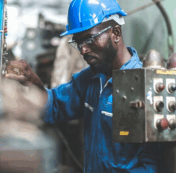 A person in a factory setting working with machinery 