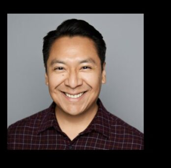 Portrait of former Great Cities Institute staff member Alex Linares smiling against a dark background. 