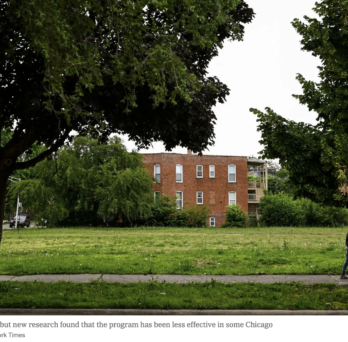 A person walks along a path through a tree-lined green space in Chicago, with a brick residential building visible in the background. Photo credit: Jamie Kelter Davis for The New York Times.
                  