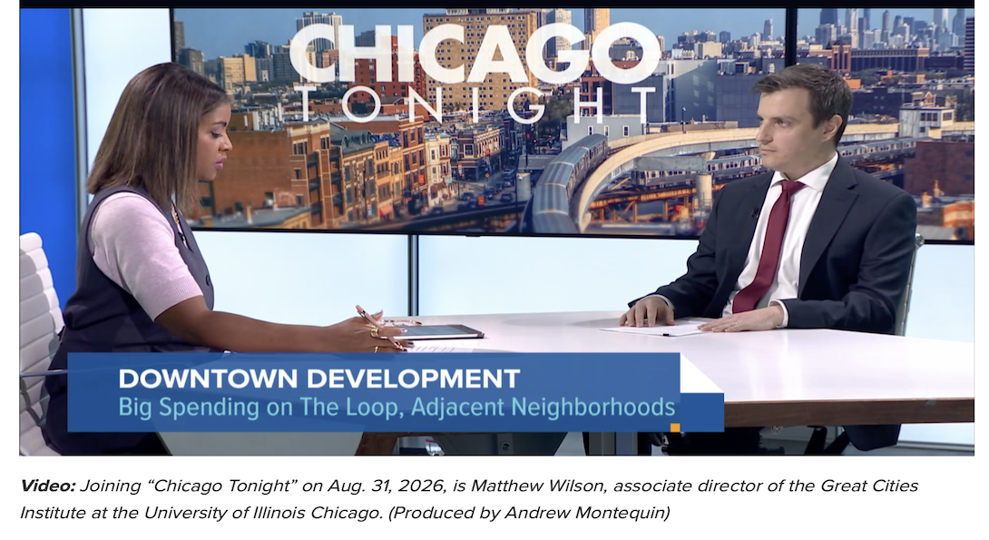 Two people seated across from each other during a “Chicago Tonight” interview, with a Chicago cityscape displayed behind them. On-screen text reads “Downtown Development: Big Spending on the Loop, Adjacent Neighborhoods.”