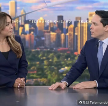 Two news anchors seated at a studio desk with the Chicago skyline displayed behind them.